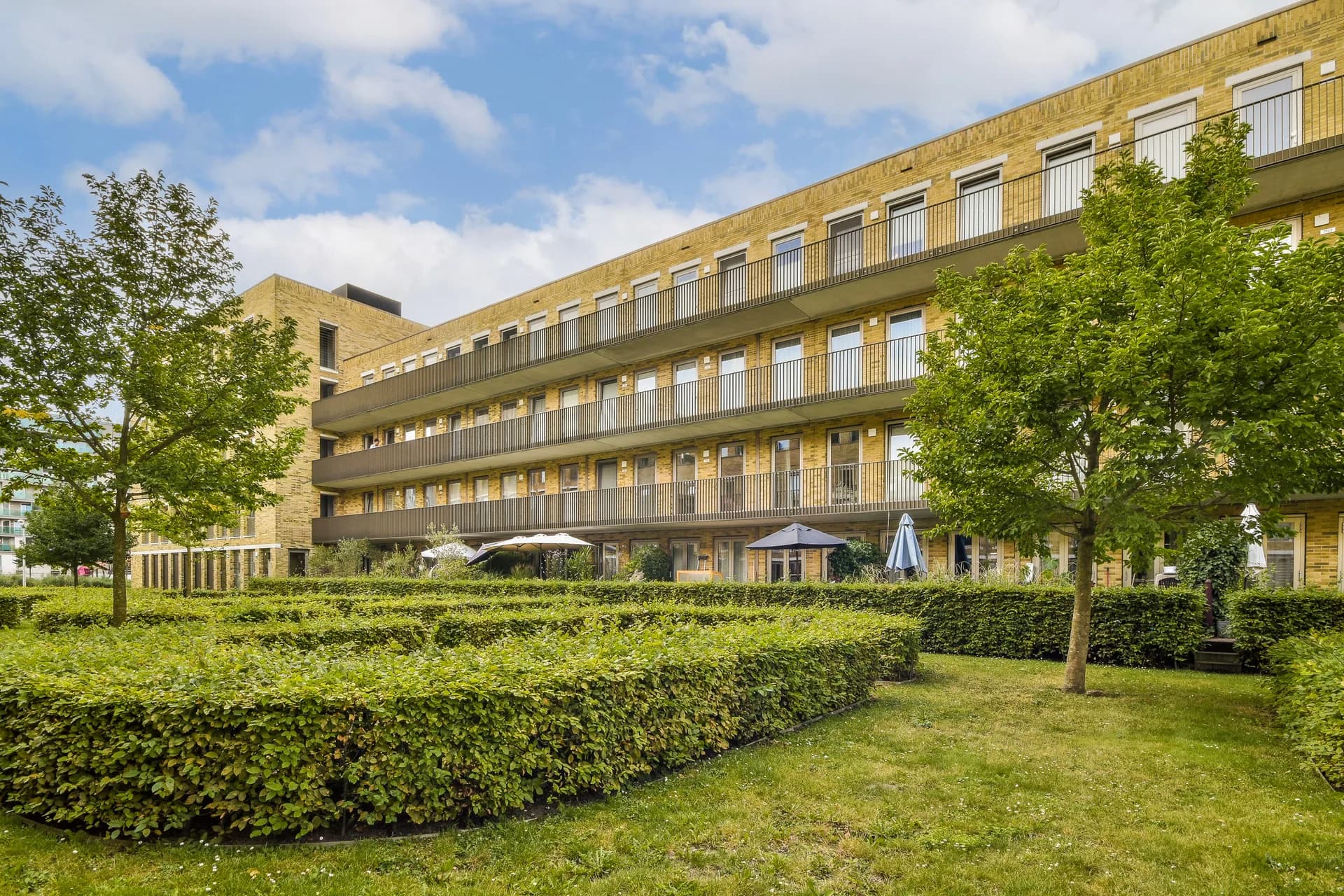 Modern apartment building with landscaped hedges